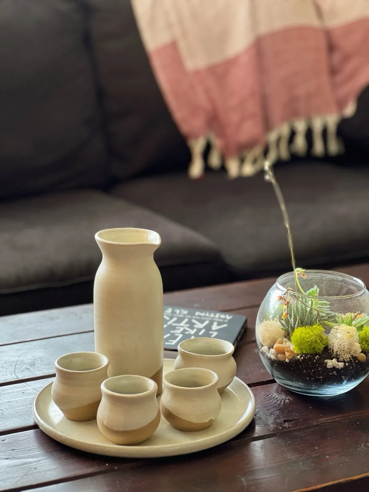 A cream sake set with a bottle and four cups on a tray