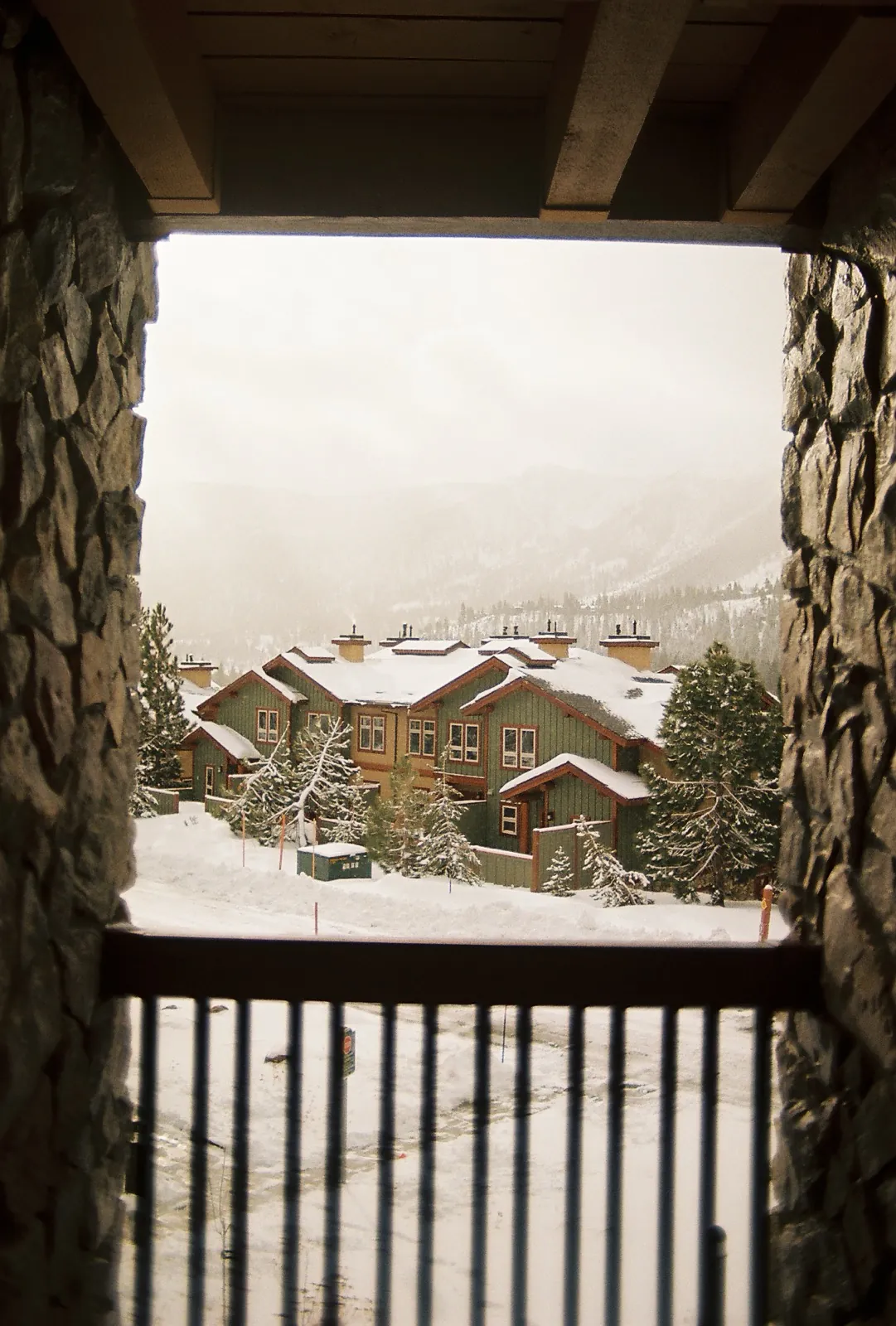 A snowy mountain village framed by a dark doorway