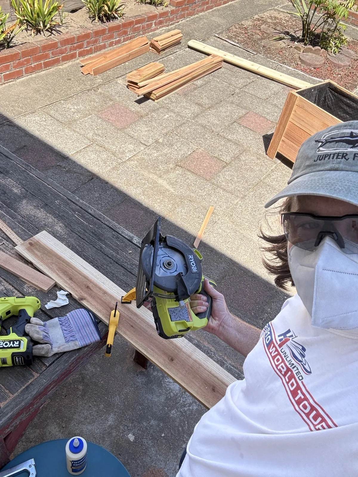 Cutting cedar boards with a circular saw, wearing a mask and safety glasses